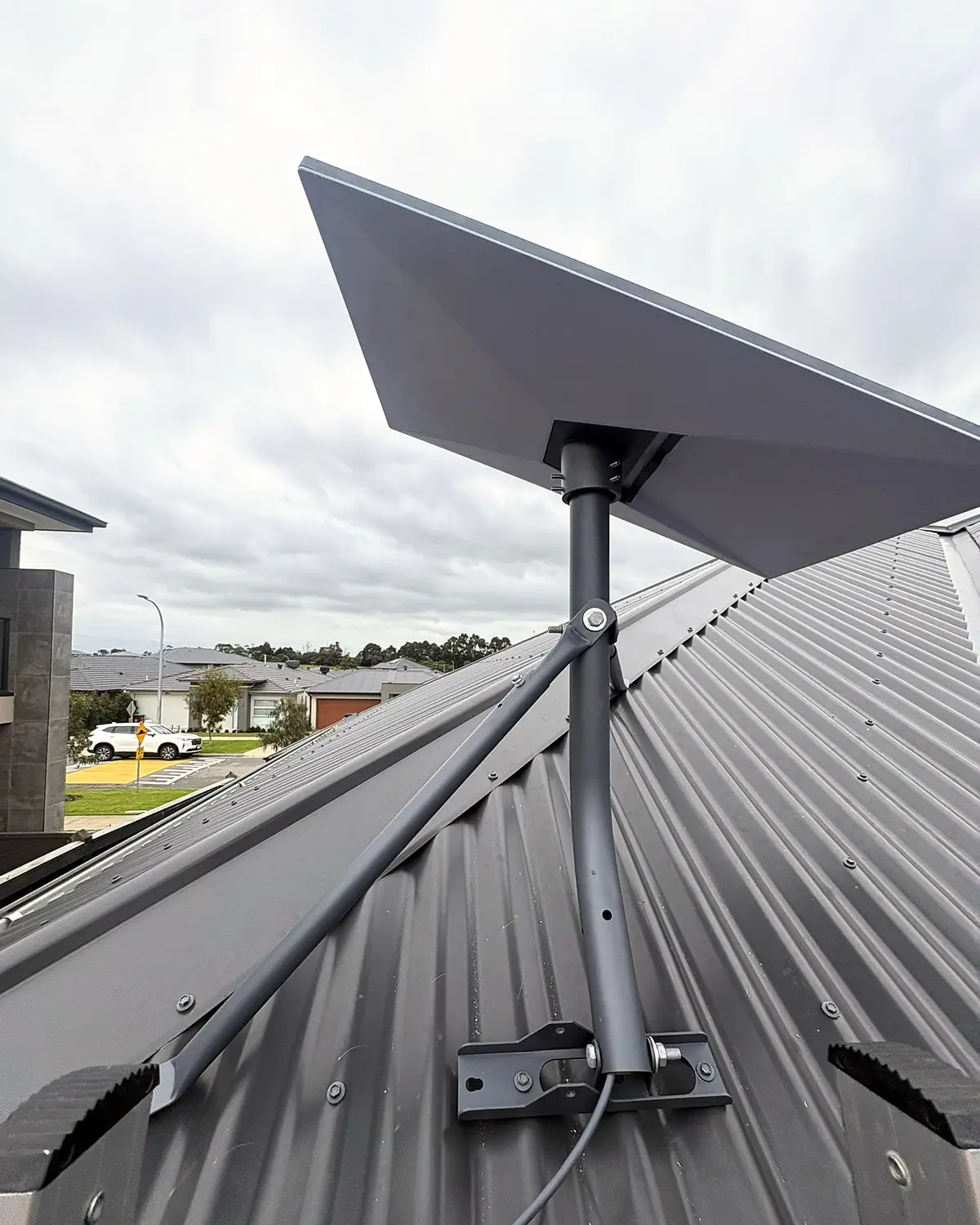 Starlink Standard dish on a tripod on a metal roof in Junction Village.