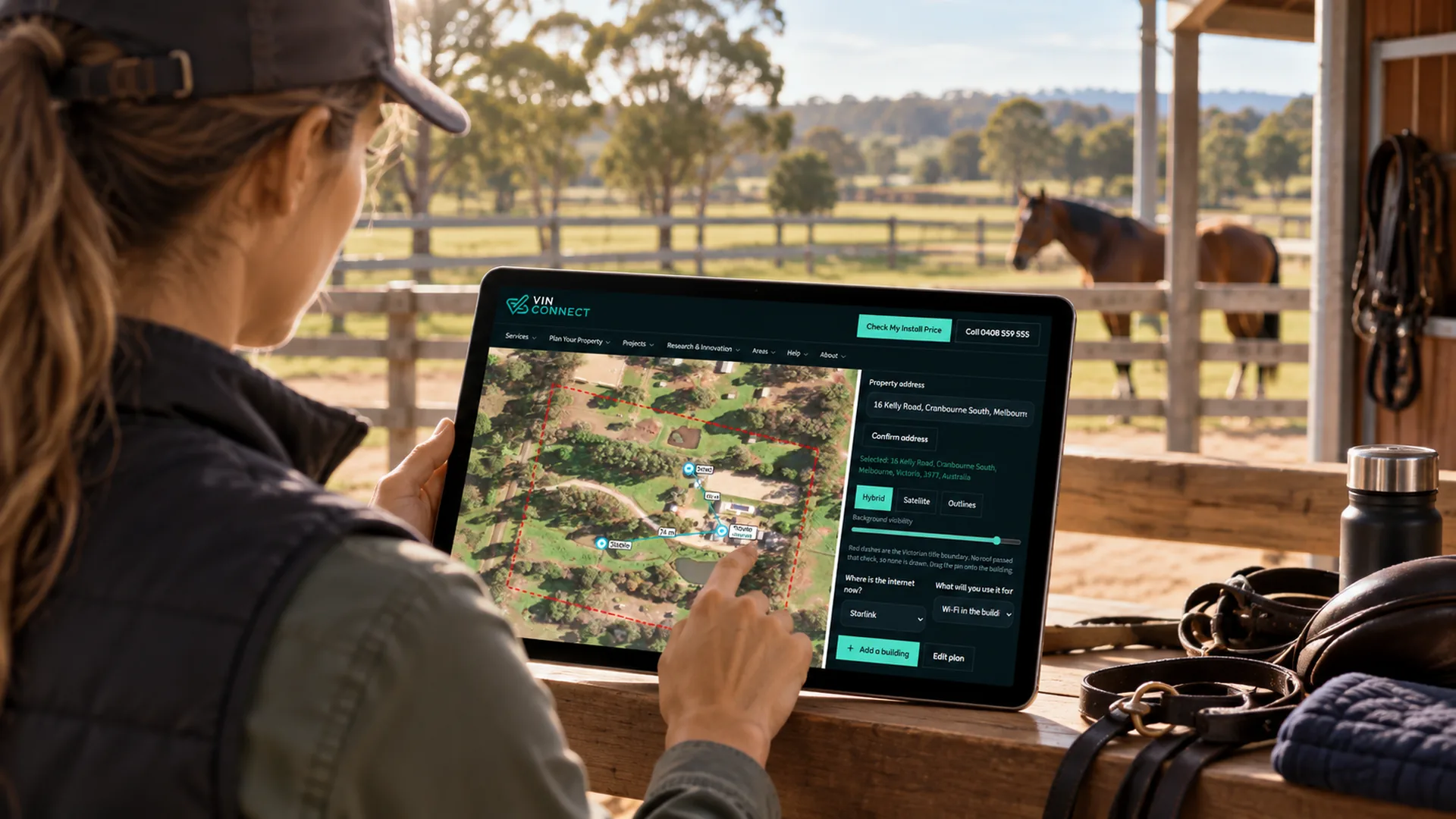 Using the VINCONNECT property planner on a tablet at a stable, with horses in the paddock.